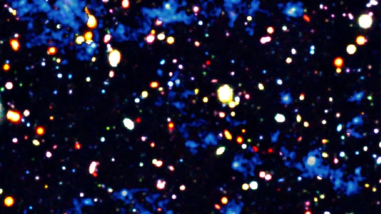 Ученые увидели газовые нити (синие) в космической паутине, которые пронизывают галактики (яркие пятна). Газ и некоторые из галактик являются частью плотного скопления галактик в процессе формирования